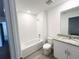 Well-lit bathroom featuring a shower-tub combo, tile floors, and a vanity with granite countertop at 16284 Hamlin View St, Winter Garden, FL 34787