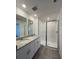 Modern bathroom with double sinks, granite countertop, and a glass-enclosed shower at 16284 Hamlin View St, Winter Garden, FL 34787