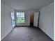 A bright, carpeted bedroom features a door to the outside and a closet at 1908 Lake Atriums Cir # 20, Orlando, FL 32839