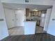 Bright kitchen with tile floors, white cabinetry and appliances, adjacent to the entry door at 1908 Lake Atriums Cir # 20, Orlando, FL 32839
