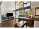 Cozy living room featuring hardwood floors, large windows, television, and comfortable seating at 200 Maitland Ave # 28, Altamonte Springs, FL 32701