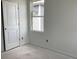 Bright bedroom featuring fresh paint, a door, and a large window, allowing natural light to illuminate the space at 2389 Zuni Road, St Cloud, FL 34771