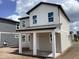 Exterior view of a new two-story home with covered porch, and large windows, located in a new development at 2389 Zuni Road, St Cloud, FL 34771