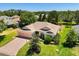 Lovely home with a brick driveway, well-kept lawn, mature trees, and a convenient three-car garage at 24104 Peekskill St, Leesburg, FL 34748