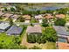 Aerial view of a neighborhood showcasing houses, streets, trees, and a serene lake in the background at 24104 Peekskill St, Leesburg, FL 34748