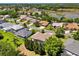 Neighborhood aerial showcasing houses with screened pools, mature trees, and a lake in the background at 24104 Peekskill St, Leesburg, FL 34748