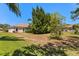 Expansive backyard featuring lush green grass and mature trees providing shade and privacy at 24104 Peekskill St, Leesburg, FL 34748