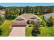 Charming home featuring a brick driveway, a well-manicured lawn, and a three-car garage at 24104 Peekskill St, Leesburg, FL 34748