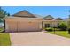 Charming home featuring a paver driveway, manicured lawn, and a three-car garage at 24104 Peekskill St, Leesburg, FL 34748