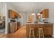 Bright kitchen featuring wood cabinets, updated appliances, and a breakfast bar with stools at 24104 Peekskill St, Leesburg, FL 34748