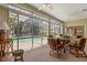 Enclosed lanai featuring comfortable seating, ceiling fans, and large windows overlooking the pool and backyard at 24104 Peekskill St, Leesburg, FL 34748