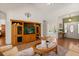 Inviting living room with vaulted ceilings, a decorative entertainment center, and views of the front entrance and bedroom at 24104 Peekskill St, Leesburg, FL 34748