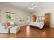 Serene primary bedroom offering wood floors, a seating area, and large windows bringing in natural light at 24104 Peekskill St, Leesburg, FL 34748
