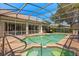 Backyard pool with screened enclosure, attached spa, and patio area, perfect for outdoor entertaining at 24104 Peekskill St, Leesburg, FL 34748