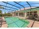 Inviting backyard pool area with a screened enclosure, patio space, and lush landscaping for privacy at 24104 Peekskill St, Leesburg, FL 34748
