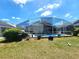 Backyard featuring a screened-in pool, lush lawn, and outdoor entertaining space at 2426 Hybrid Dr, Kissimmee, FL 34758