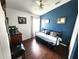 Stylish bedroom featuring dark wood floors, a blue accent wall, and cozy daybed at 2426 Hybrid Dr, Kissimmee, FL 34758