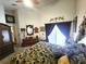 Cozy main bedroom featuring high ceilings, a ceiling fan, and a large window at 2426 Hybrid Dr, Kissimmee, FL 34758
