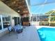 Outdoor pool patio featuring covered tiki bar and screened-in pool at 2426 Hybrid Dr, Kissimmee, FL 34758