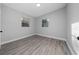 Bedroom featuring two windows, light gray walls, light-colored wood-look flooring, and white trim at 2614 Rio Ln, Orlando, FL 32805
