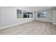 Bright living room featuring neutral walls, gray wood flooring, and multiple windows at 2614 Rio Ln, Orlando, FL 32805