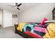 Bright bedroom featuring a ceiling fan, neutral walls and colorful patterned bedding at 289 Magnolia Park Trl, Sanford, FL 32773