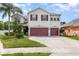 Charming two-story home featuring a well-manicured lawn and a two-car garage, complemented by lush landscaping at 289 Magnolia Park Trl, Sanford, FL 32773