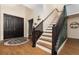 Elegant foyer with hardwood floors, staircase with dark wood trim, and a stylish entryway at 289 Magnolia Park Trl, Sanford, FL 32773