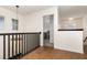 Hallway area featuring wood floors, black railings, and a unique pendant light fixture at 289 Magnolia Park Trl, Sanford, FL 32773