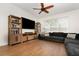 Cozy living room featuring a large TV, built-in shelving, hardwood floors, and comfortable seating at 289 Magnolia Park Trl, Sanford, FL 32773