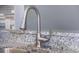 Modern faucet detail set atop granite countertops in a stylish kitchen at 3004 Cottage Grove Ct # 1805, Orlando, FL 32822