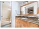 Bathroom features wooden vanity with granite countertop and tiled shower at 3221 Westridge Blvd # 103, Orlando, FL 32822