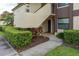 Charming condo entrance featuring a private walkway, manicured hedges, and neutral stucco facade at 3221 Westridge Blvd # 103, Orlando, FL 32822