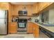 Well-equipped kitchen featuring stainless steel appliances and plenty of wood cabinetry at 3221 Westridge Blvd # 103, Orlando, FL 32822