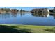 Community pond reflecting apartment complex with lush green grounds at 3702 Palm Desert Ln # 5435, Orlando, FL 32839