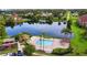 Aerial view of a community pool overlooking a pond with palm trees around the perimeter at 3702 Palm Desert Ln # 5435, Orlando, FL 32839