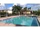 Community pool featuring clear water, lush landscaping, pergola and nearby apartment buildings at 3702 Palm Desert Ln # 5435, Orlando, FL 32839