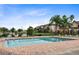 A sparkling pool, buildings, and pond in a well-maintained community offer a relaxing and attractive amenity at 3702 Palm Desert Ln # 5435, Orlando, FL 32839