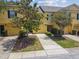 Exterior of a townhouse featuring yellow siding, a garage, and landscaping at 3759 Collingwood Ln, Oviedo, FL 32765