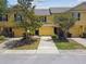 Townhouse exterior featuring yellow siding, a garage, and landscaping at 3759 Collingwood Ln, Oviedo, FL 32765