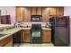 Contemporary kitchen showcasing sleek black appliances, granite counters and wood cabinetry, offering functionality at 3759 Collingwood Ln, Oviedo, FL 32765