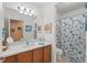 Bright bathroom features a shower-tub combination and vanity with framed mirror at 3824 Gulf Shore Cir, Kissimmee, FL 34746
