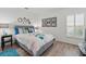 Modern bedroom features a grey bed frame, white walls, and window with plantation shutters at 3824 Gulf Shore Cir, Kissimmee, FL 34746