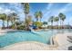 Resort-style community pool with a water slide, surrounded by palm trees and lounge chairs, perfect for relaxation and fun at 3824 Gulf Shore Cir, Kissimmee, FL 34746