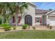 Detailed close-up of a home's facade featuring a covered entry, landscaped beds, and architectural details at 3824 Gulf Shore Cir, Kissimmee, FL 34746