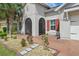 Detailed close-up of the front facade showing the arched entry with landscaping, architectural trim and a brick walkway at 3824 Gulf Shore Cir, Kissimmee, FL 34746