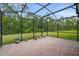 Screened in patio has brick flooring offering scenic views of the lush backyard at 3824 Gulf Shore Cir, Kissimmee, FL 34746