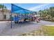 Community playground with blue shade, play equipment, soft surface, and lush landscaping at 3824 Gulf Shore Cir, Kissimmee, FL 34746