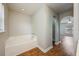 A bathroom with a tiled tub and shower area next to an archway leading to a room with hardwood flooring at 4113 Stonefield Dr, Orlando, FL 32826