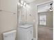 This bathroom features a toilet, vanity, mirror, lighting, and door leading to a bedroom with a ceiling fan at 4153 Cortland Dr, Davenport, FL 33837